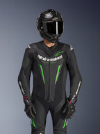 Alpinestars GP Force V2 Lederkombi – 1-teilig, Schwarz und Grün, Motorrad-Rennanzug getragen mit einem Carbonfaser-Helm und GP Pro Handschuhen, mit limettengrünen Akzenten und Alpinestars „Racing Ahead“-Branding, entwickelt für Rennstrecken-Performance.