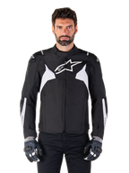 Alpinestars T-Jaws V4 Waterproof Jacke, Schwarz und Weiß, sportliche Textil-Motorradjacke für Herren, mit weißem Stern-Logo auf der Brust, weißen Schulterakzenten und weißen Streifen an den Unterarmen, hochgeschlossener Kragen, athletische Passform für die Straße