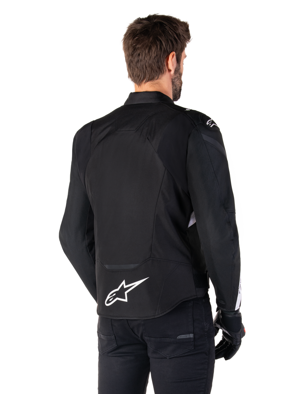 Alpinestars T-Jaws V4 Wasserdichte Jacke, Schwarz und Weiß, Rückansicht, Textil-Sportmotorradjacke mit weißem Logo am unteren Rücken, getragen mit schwarzen Handschuhen und Hosen, mit einer überarbeiteten sportlichen Silhouette