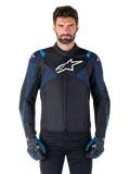 Alpinestars T-Jaws V4 Wasserdichte Jacke, Motorradjacke, Schwarz und Dunkelblau mit Blithe Blue Akzenten, weißes Logo auf der Brust, blauer Schriftzug auf den Schultern, getragen mit passenden Handschuhen, wasserdichte Textil-Fahrausrüstung