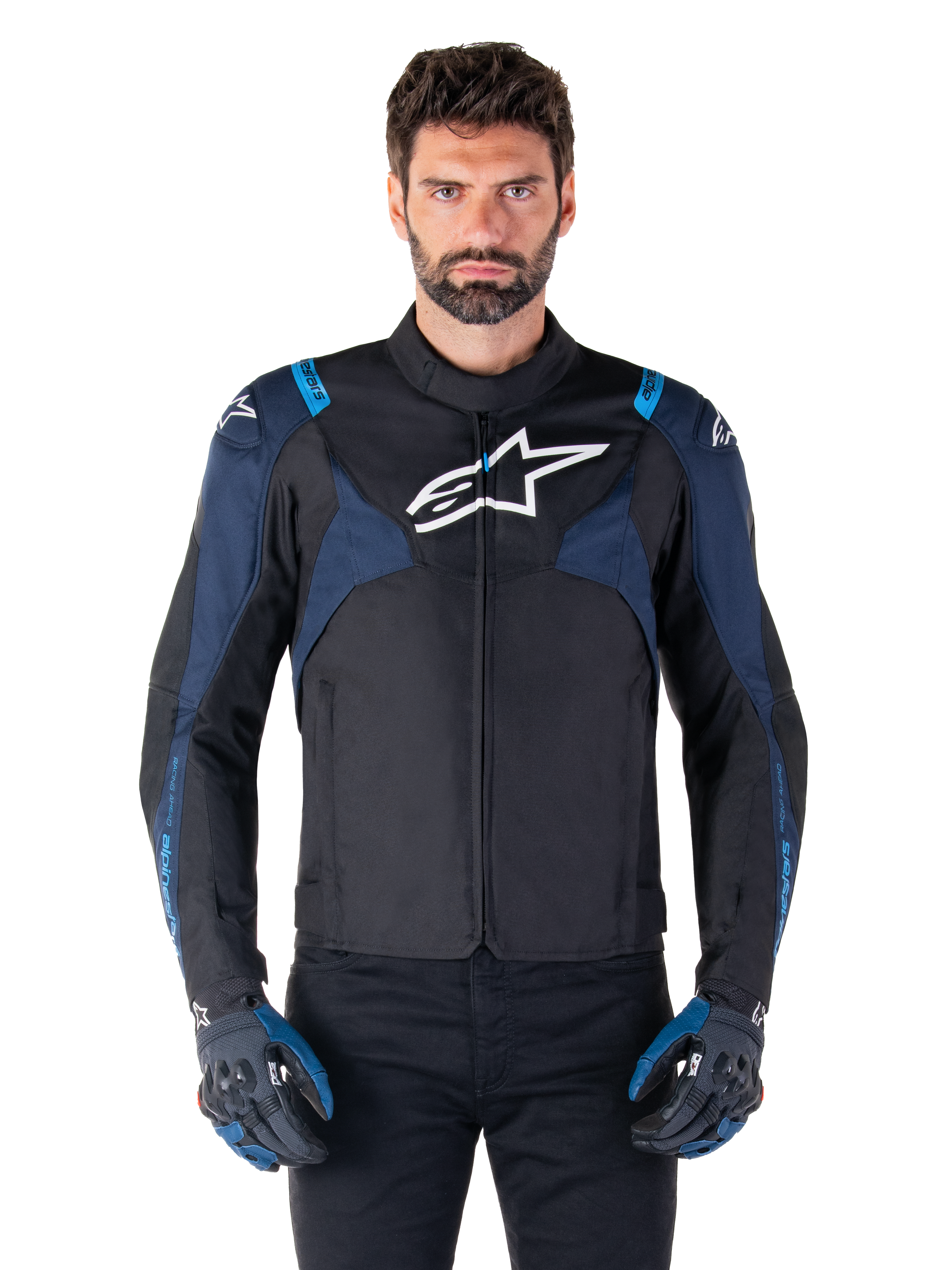 Alpinestars T-Jaws V4 Wasserdichte Jacke, Motorradjacke, Schwarz und Dunkelblau mit Blithe Blue Akzenten, weißes Logo auf der Brust, blauer Schriftzug auf den Schultern, getragen mit passenden Handschuhen, wasserdichte Textil-Fahrausrüstung