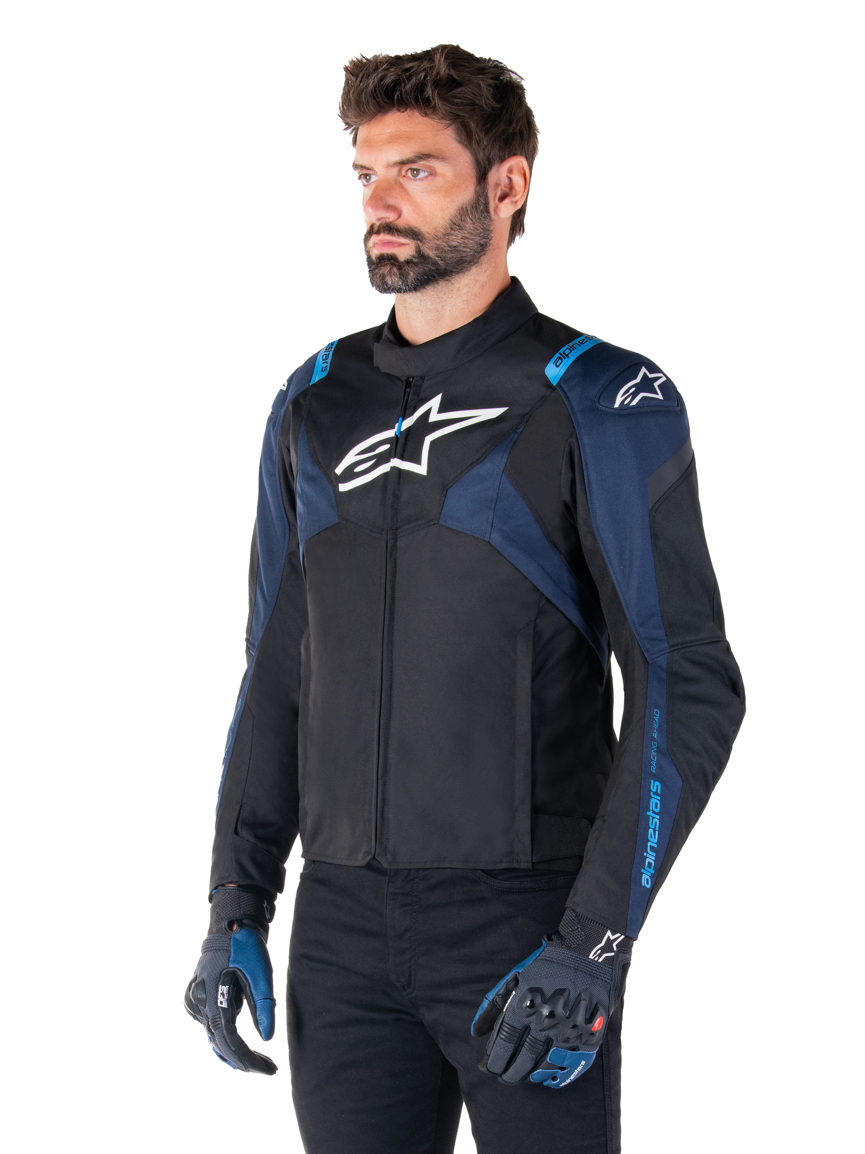 Alpinestars T-Jaws V4 Wasserdichte Jacke, Motorradjacke, Schwarz, Dunkelblau und Blithe Blue, getragen von einem Model mit passenden Handschuhen und schwarzer Hose, mit weißen Alpinestars-Logos auf der Brust und den Schultern sowie blauen Akzenten an den Ärmeln, sportliche Textil-Fahrausrüstung