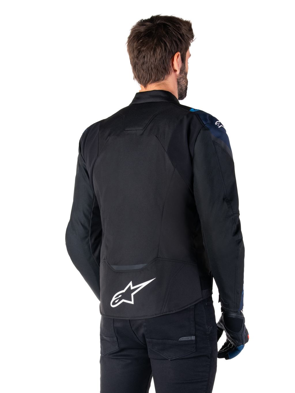 Alpinestars T-Jaws V4 Wasserdichte Jacke, Rückansicht, Schwarz mit dunkelblauen und hellblauen Details, weißes Stern-Logo am unteren Rücken, sportliche Silhouette, getragen mit schwarzer Hose und Motorradhandschuhen