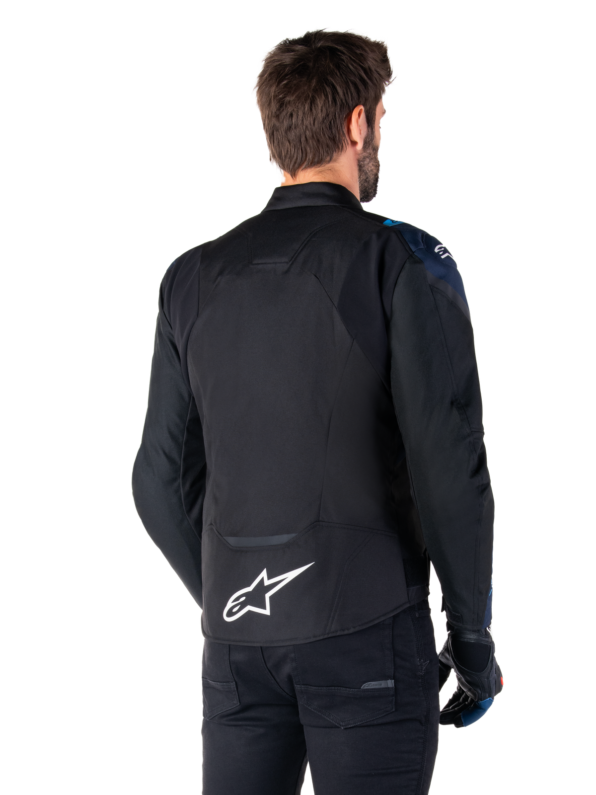Alpinestars T-Jaws V4 Wasserdichte Jacke, Rückansicht, Schwarz mit dunkelblauen und hellblauen Details, weißes Stern-Logo am unteren Rücken, sportliche Silhouette, getragen mit schwarzer Hose und Motorradhandschuhen