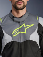 Alpinestars T-Jaws V4 Waterproof Jacke, Schwarz, Ice Gray und Dunkelgrau, Detailansicht von Brust und Kragen, mit einem markanten neongelben Alpinestars Stern-Logo und Branding auf den Schultern, strapazierfähiges Textilmaterial für das Motorradfahren
