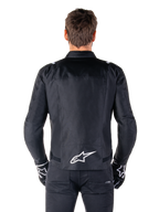 Alpinestars T-SPS V2 Wasserdichte Jacke, Schwarz und Weiß, Rückansicht mit weißem Alpinestars-Logo auf dem unteren Rücken, getragen mit schwarzer Hose und Handschuhen, sportlich geschnittene Textil-Motorradjacke