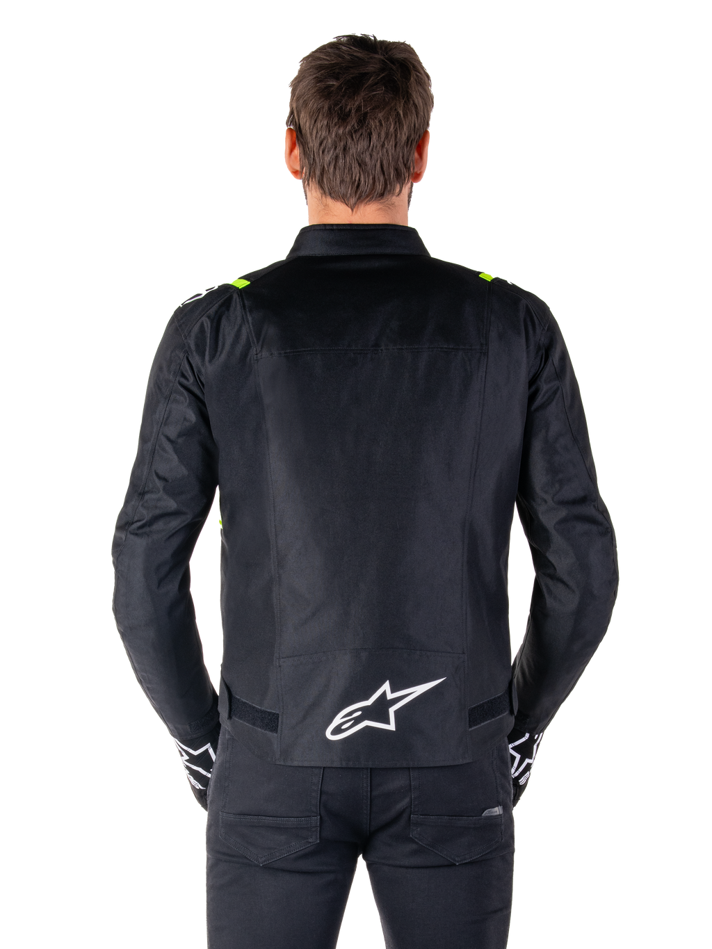 Alpinestars T-SPS V2 Wasserdichte Jacke, Rückansicht, Schwarz mit Yellow Fluo Akzenten an den Schultern und weißem Stern-Logo auf dem unteren Rücken, Textil-Motorradjacke mit sportlicher Silhouette, von einem männlichen Model getragen