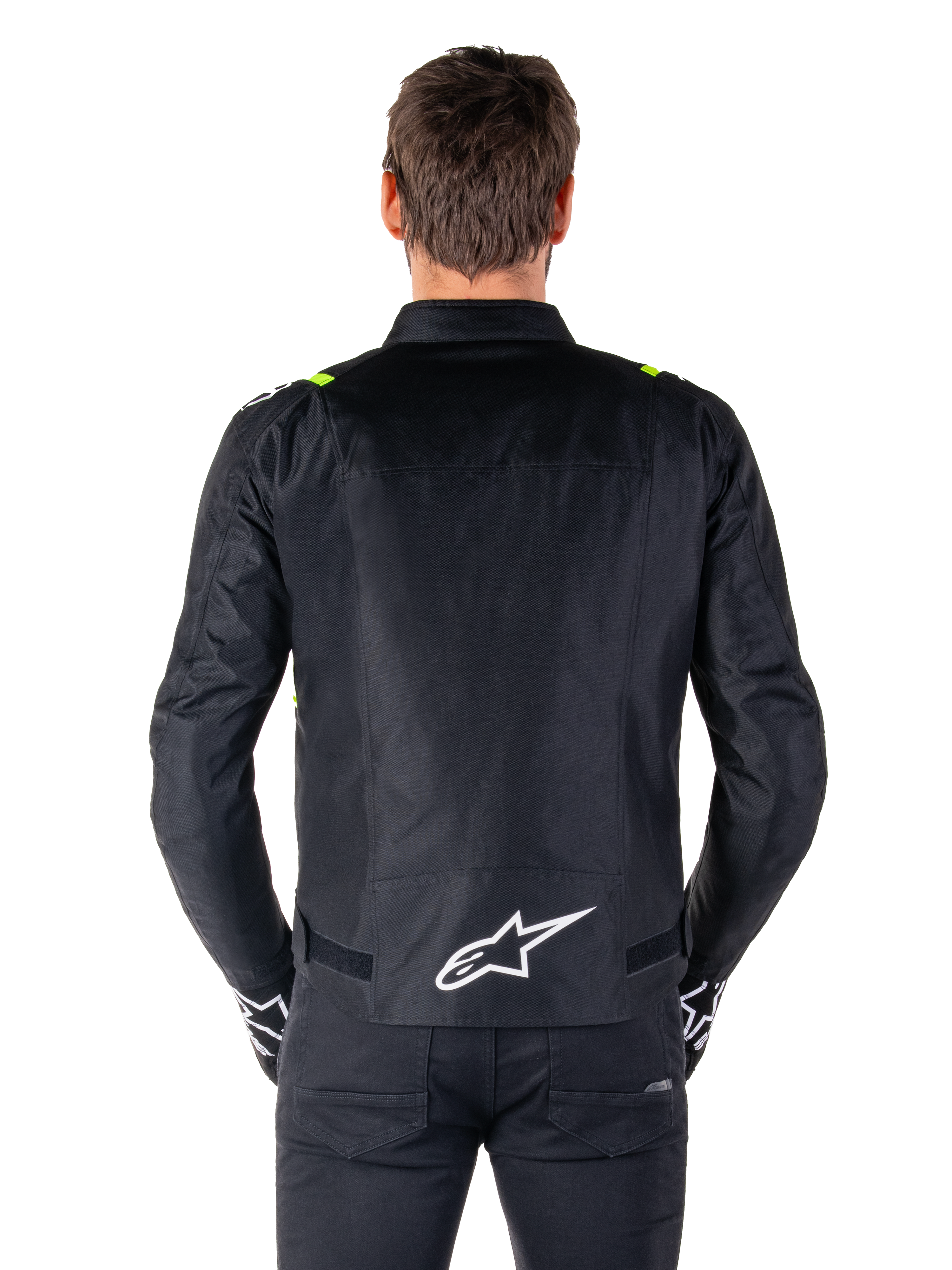 Alpinestars T-SPS V2 Wasserdichte Jacke, Rückansicht, Schwarz mit Yellow Fluo Akzenten an den Schultern und weißem Stern-Logo auf dem unteren Rücken, Textil-Motorradjacke mit sportlicher Silhouette, von einem männlichen Model getragen