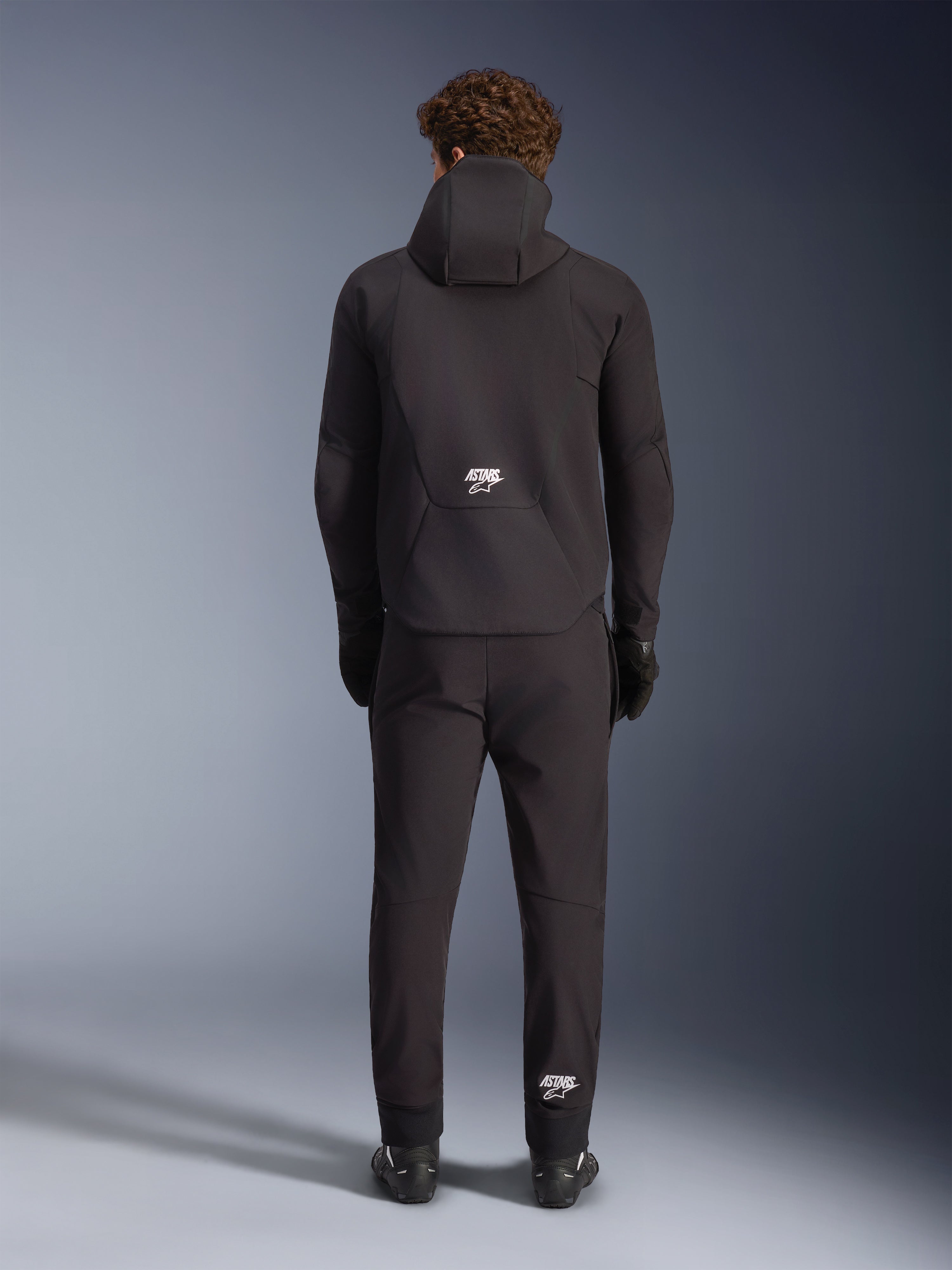 Alpinestars Aeroshell Wasserdichte Jacke, schwarze Motorrad-Softshell-Kapuzenjacke, Herren, Rückansicht mit weißem ASTARS-Logo.