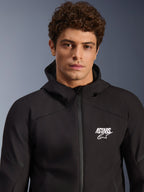 Alpinestars Aeroshell Wasserdichte Jacke, schwarzer Motorrad-Softshell-Hoodie für Herren, weißes ASTARS-Logo, wasserdichtes Textilmaterial, modernes Studioporträt.