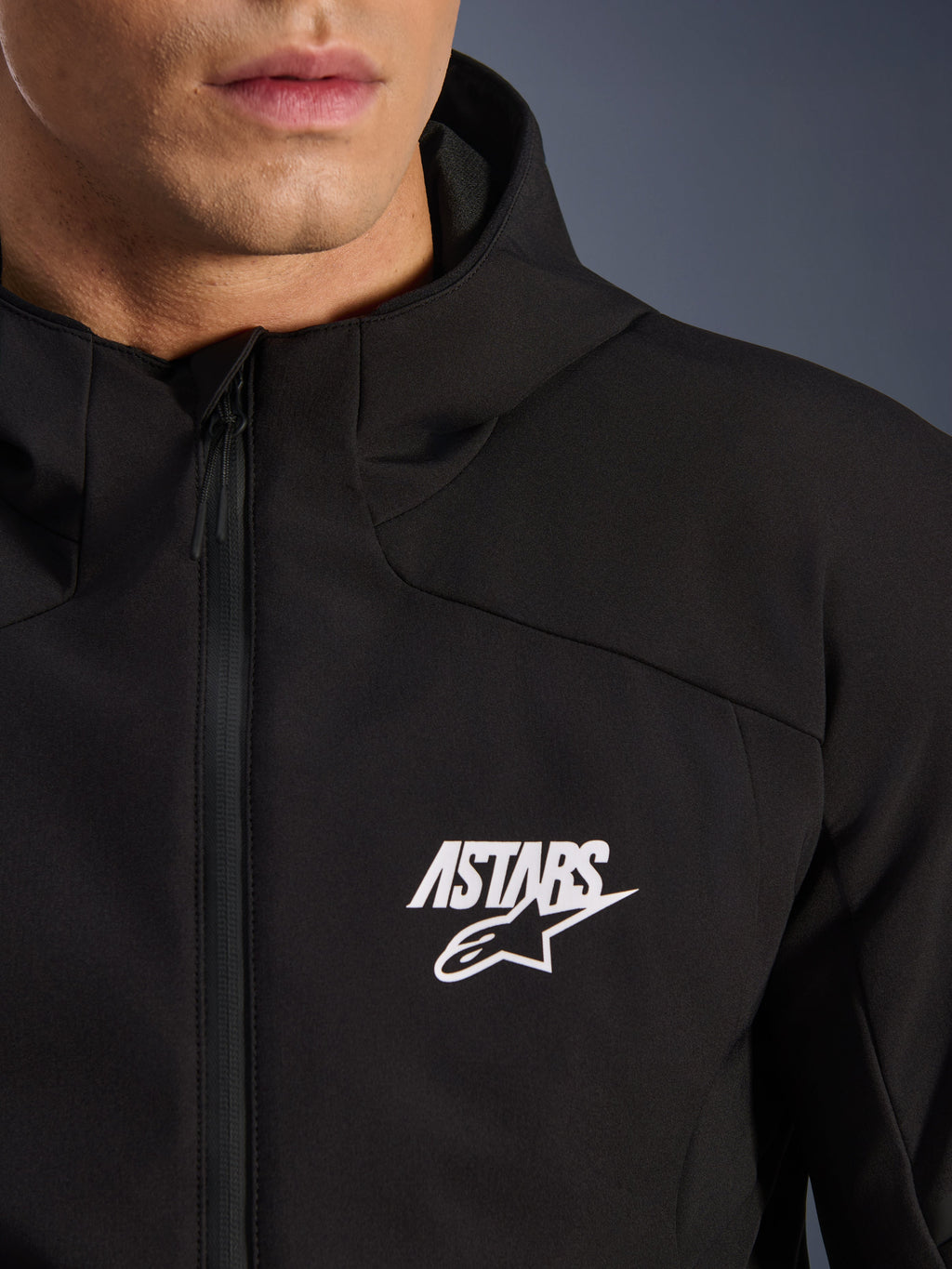 Alpinestars Aeroshell Wasserdichte Jacke, schwarze Herren Motorrad-Softshelljacke mit weißem ASTARS Stern-Logo, wasserdichtem Frontreißverschluss und integrierter Kapuze.