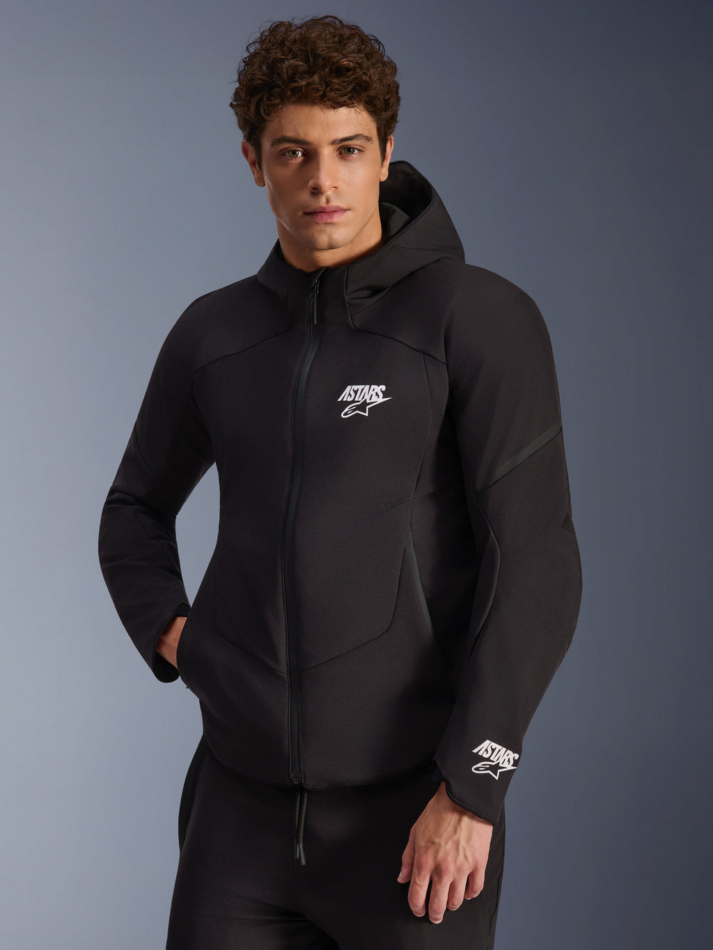 Alpinestars Aeroshell Wasserdichte Jacke, schwarze Herren-Softshell-Motorradjacke mit Kapuze und weißen Astars-Logos.