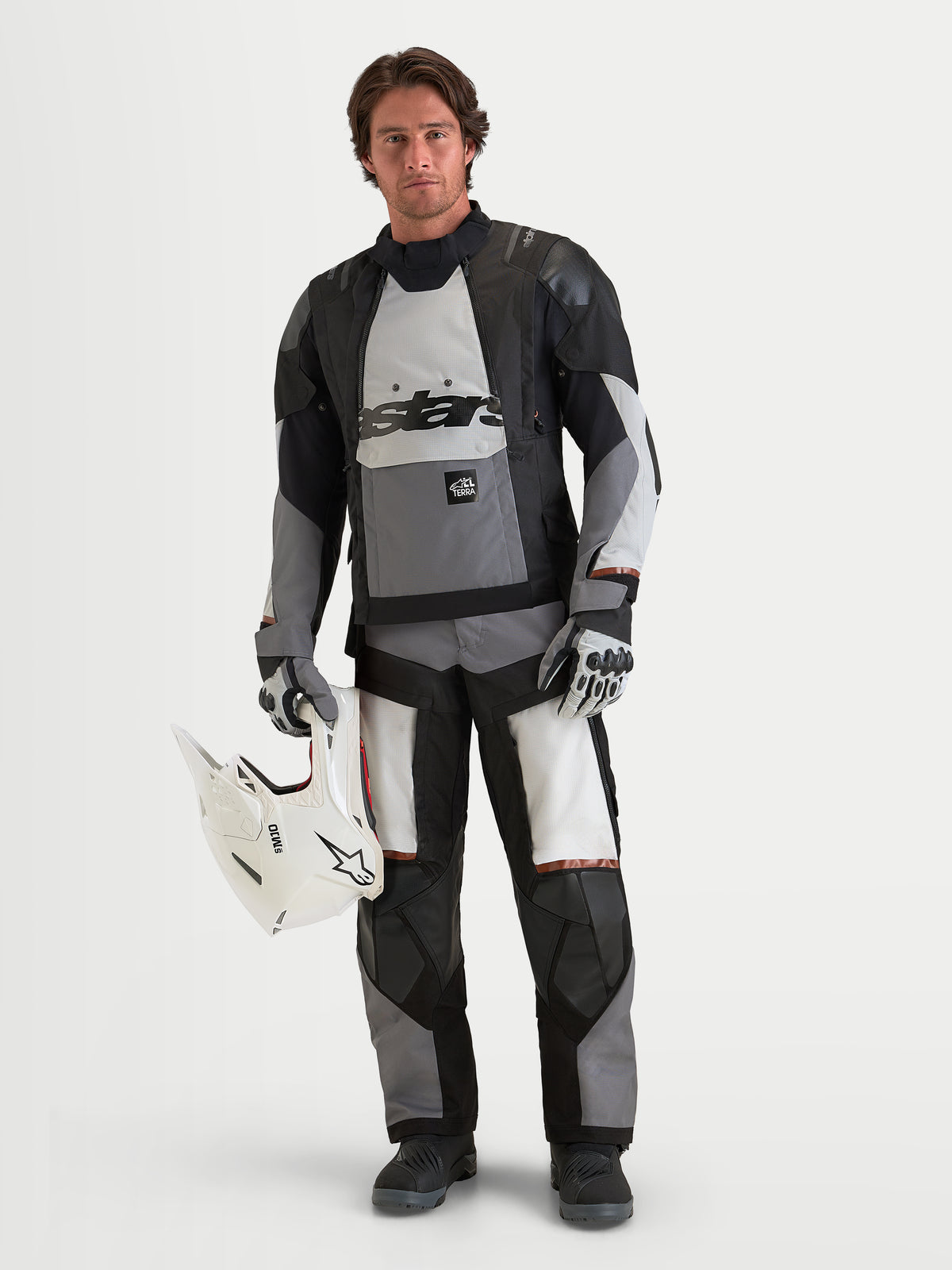 Alpinestars Harok V2 Drystar Jacke, Herren-Abenteuer-Motorradjacke, Dunkelgrau, Eisgrau und Schwarz, wasserdichte Textilkonstruktion mit CE-zertifiziertem Schutz, getragen von einem männlichen Model mit einem weißen Helm
