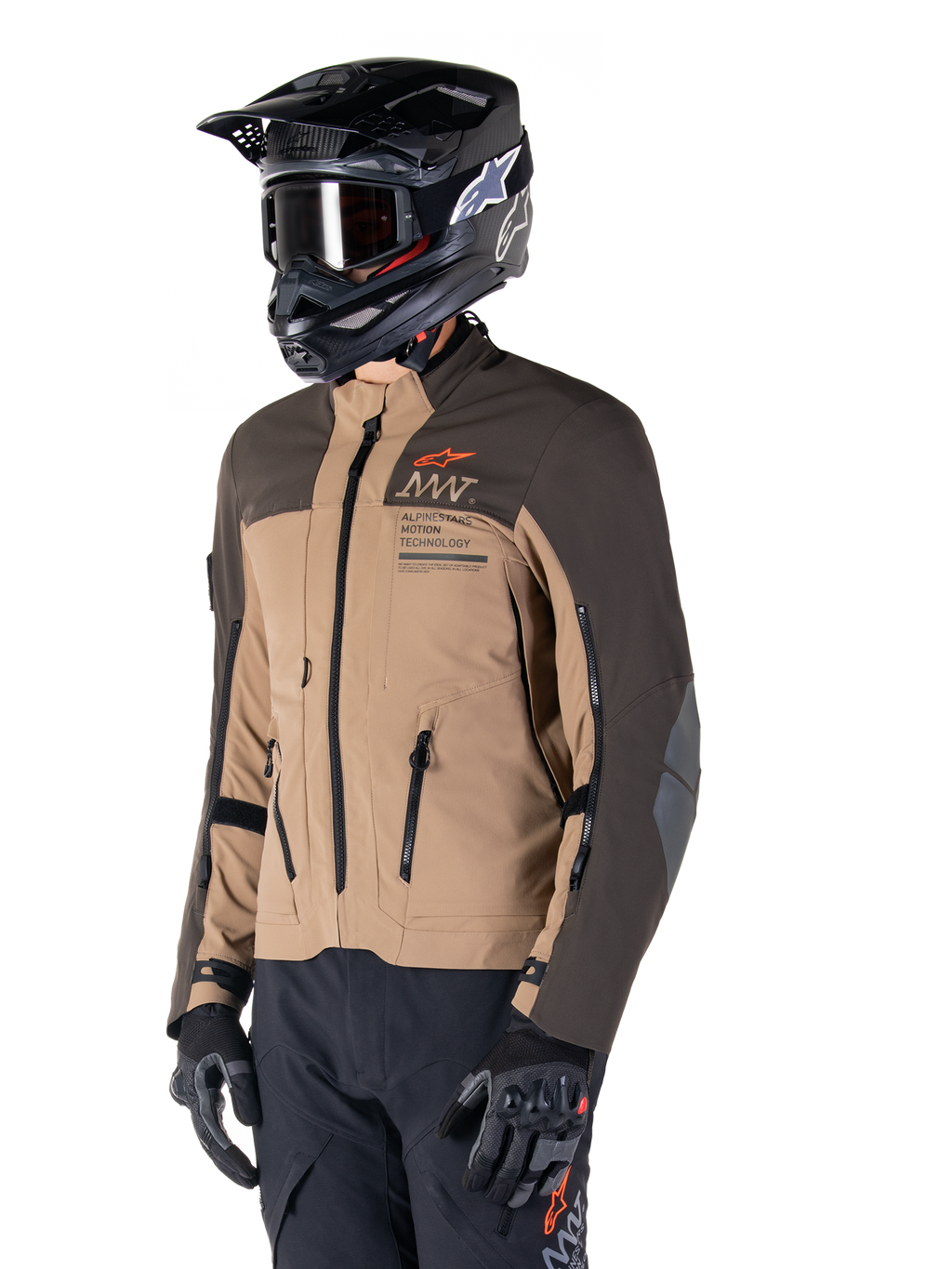 Alpinestars AMT-8 Stretch Drystar® XF Jacke, Adventure-Motorradjacke, Dunkelbraun und Dunkles Khaki, getragen mit einem schwarzen Offroad-Helm und Goggles, mit Alpinestars Motion Technology Branding und Belüftungsöffnungen mit Reißverschluss.