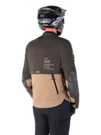 Alpinestars AMT-8 Stretch Drystar® XF Jacke, Adventure-Motorradjacke, Dunkelbraun und Dunkles Khaki, Rückansicht mit AMT Alpinestars Motion Technology Branding, zweifarbiges Textildesign mit Belüftungsreißverschlüssen am Rücken und Luftauslass im Schindel-Design, getragen mit schwarzem Helm und Motorradhose