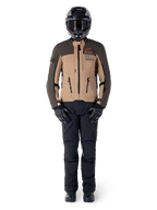 Alpinestars AMT-8 Stretch Drystar® XF Jacke, Adventure-Motorradjacke, Dunkelbraun und Dunkelkhaki, getragen mit schwarzem Helm, Goggles, schwarzen Handschuhen, schwarzer Hose und schwarzen Stiefeln, mit Belüftungsöffnungen an der Brust und AMT-Branding, abgestimmte Ausrüstung für Adventure-Touren
