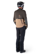 Alpinestars AMT-8 Stretch Drystar® XF Jacke, Adventure-Touring-Motorradjacke, Dunkelbraun und Dunkelkhaki, Rückansicht mit 'AMT Alpinestars Motion Technology'-Branding, getragen mit schwarzer Hose und Helm, ergonomisches Stretch-Design für Adventure-Fahrten