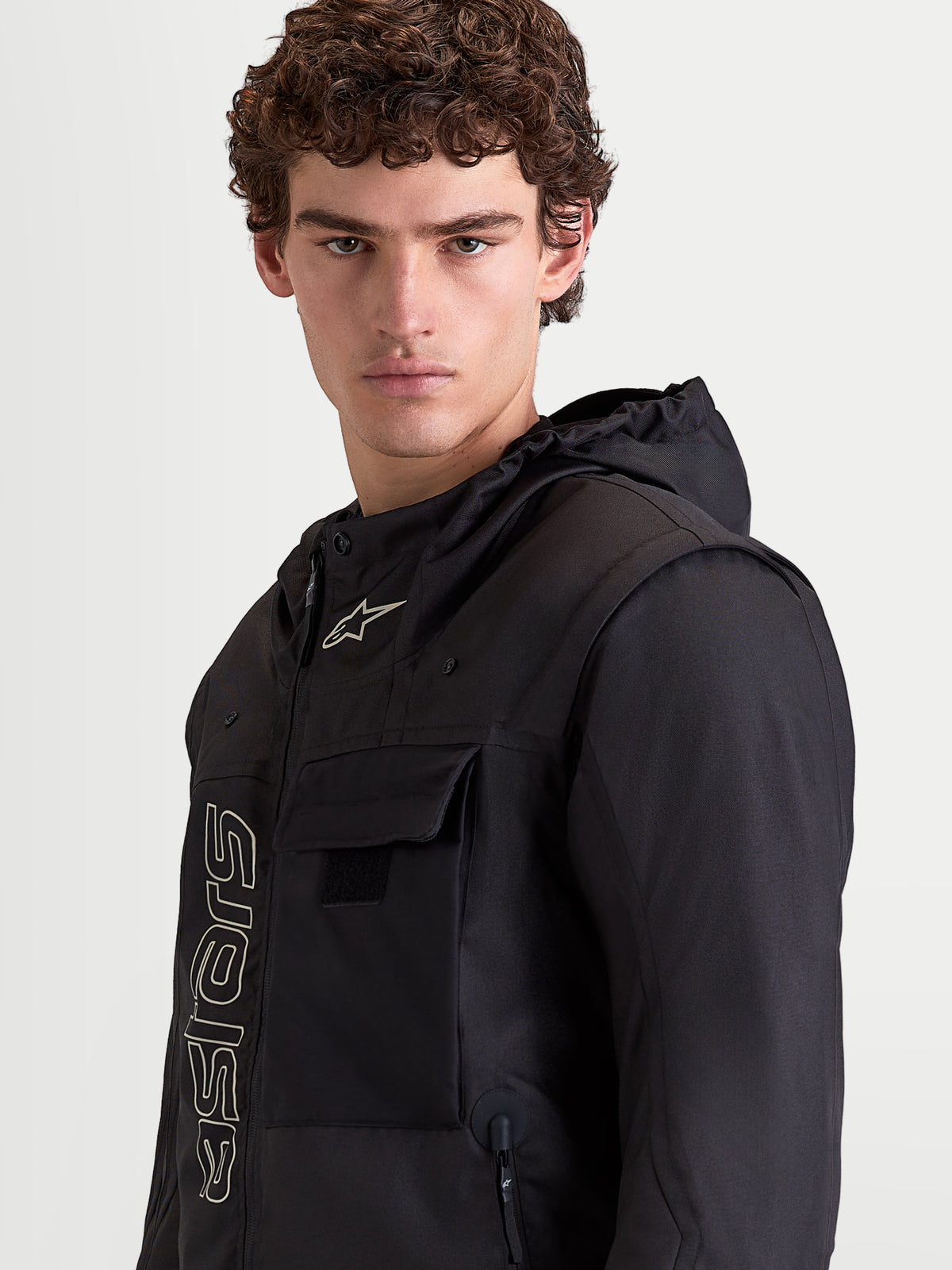 Alpinestars Morfex Parka Wp Jkt, schwarze Urban-Motorradjacke für Herren, Porträtfoto des Models mit integrierter Kapuze und Brusttaschendetails