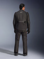 Rückansicht eines männlichen Fahrers in der Alpinestars Andes V4 Drystar® Jacke in Schwarz, kombiniert mit passender Motorradhose und Handschuhen, mit Alpinestars-Logo und -Schriftzug auf dem Rücken, technische Allwetter-Adventure-Ausrüstung