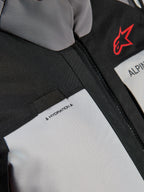 Alpinestars Andes V4 Drystar® Jacket, close-up detail of the chest, Dark Gray and Ice Gray panels with black textile reinforcements, featuring a red Alpinestars logo and a hydration hose loop with 'HYDRATION' label