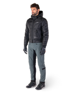 Alpinestars Mohobbs Waterproof Jacket, Black, quilted urban motorcycle bomber jacket with hood, worn by a model with grey riding pants and black gloves, featuring a white chest logo, contemporary streetwear-inspired protective gear