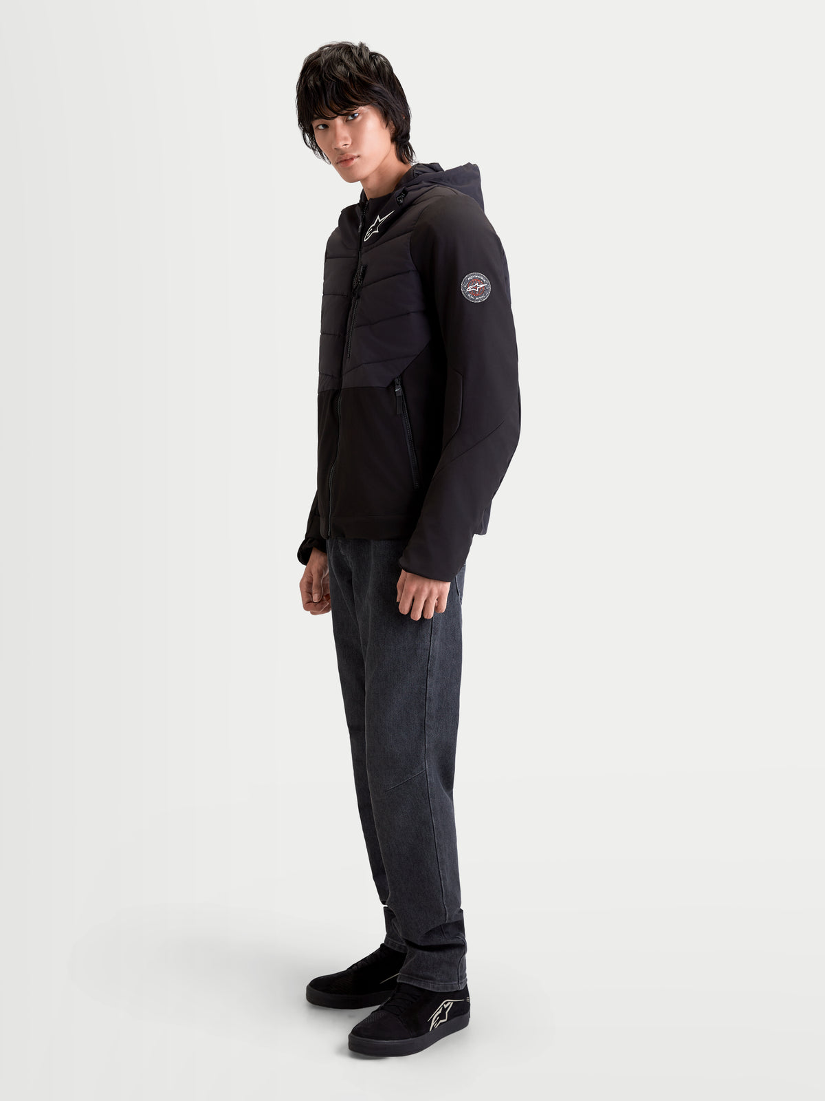 Alpinestars Therma-Tech Waterproof Jacket, men's urban contemporary motorcycle jacket in black, side profile view worn by a model showing sonic-welded down construction and integrated hood.