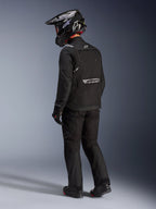 Alpinestars Cusco Drystar® Jacke in Schwarz, Rückseitenansicht eines Fahrers in kompletter Adventure-Tourenausrüstung inklusive passender schwarzer Hose und Handschuhen, schwarzer Adventure-Helm, Textilkonstruktion mit reflektierendem Branding auf dem Rücken