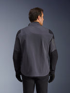 Alpinestars Maxdura Drystar®XF Laminierte Gepanzerte Jacke, technische Adventure-Jacke, Deep Gray und Schwarz, Rückansicht mit verstärkten Schulter- und Ellbogenpaneelen, dezentes Logo am oberen Rücken, getragen mit schwarzen Handschuhen und Hosen, entwickelt für Allwetterschutz.