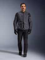 Maxdura Drystar®XF Laminierte Gepanzerte Jacke, Motorradjacke, Dunkelgrau-Schwarz, getragen von einem Modell mit schwarzer Hose und Handschuhen, mit großen Cargotaschen, roten Reißverschlussakzenten und All Terra-Branding, technische Adventure-Fahrausrüstung