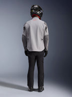 Alpinestars Maxdura Drystar®XF Laminated Armored Shell, Motorradjacke in Mittelgrau und Dunkelgrau, Rückansicht an einem Fahrer, getragen mit schwarzer Hose, schwarzen Stiefeln und einem schwarz-weißen Helm, Adventure-Touring-Ausrüstung