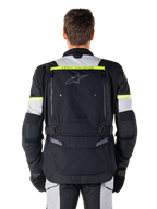 Alpinestars Bogota' Pro Drystar® Jacke, Adventure-Touring-Motorradjacke, Schwarz, Ice Gray und Gelb Fluo, Rückansicht mit „TECH TOURING“-Branding auf einem fluoreszierenden gelben Streifen, großem Belüftungspanel am Rücken und verstellbaren Taillengurten, technische Ganzjahresausrüstung