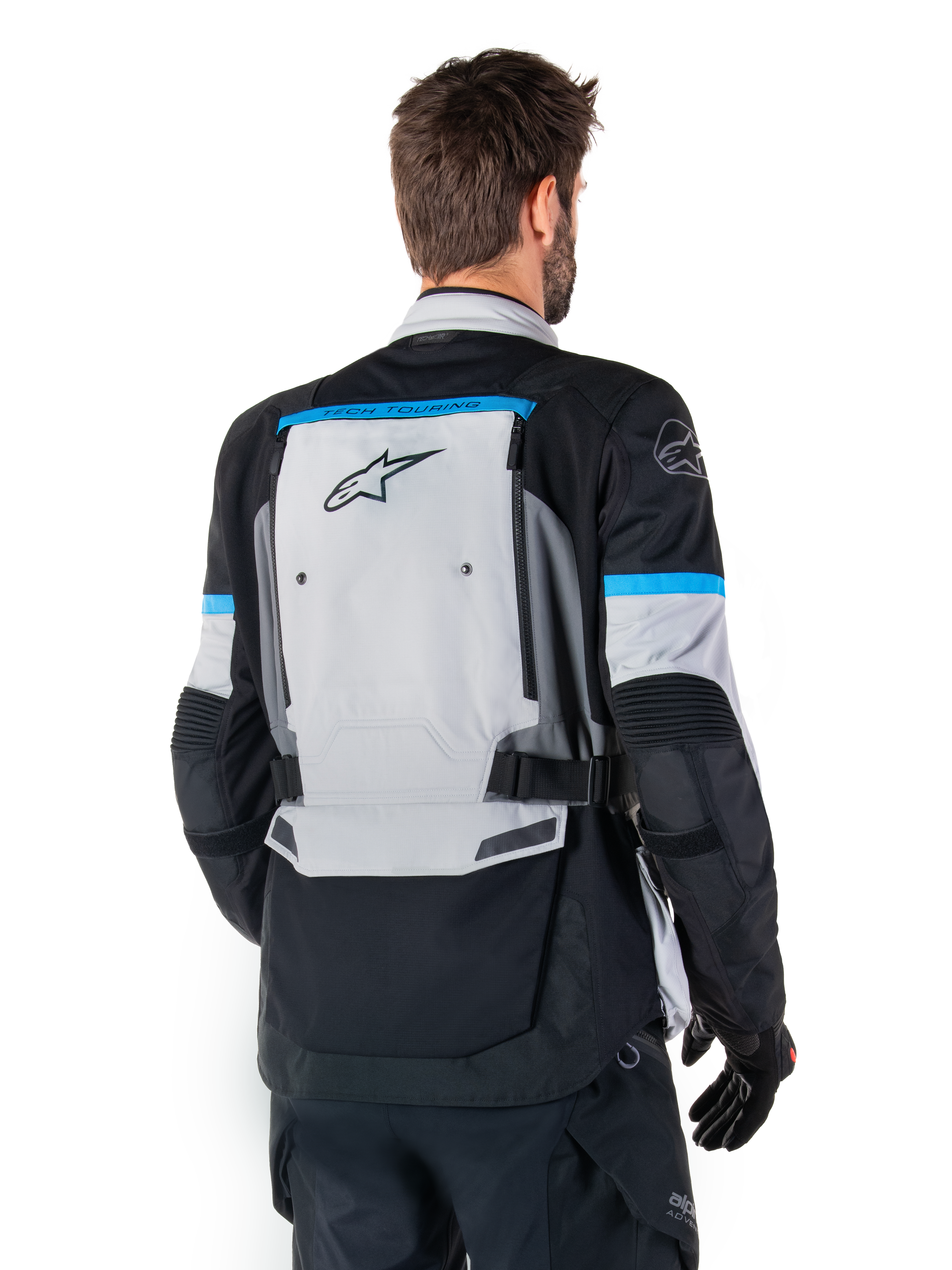 Alpinestars Bogota' Pro Drystar® Jacke, Adventure-Motorradjacke, Ice Gray, Schwarz und Cyan, Rückansicht mit Fokus auf dem großen grauen Rückenpanel mit Tech Touring-Branding, cyanfarbene Akzente an den Ärmeln, strapazierfähige Textilkonstruktion