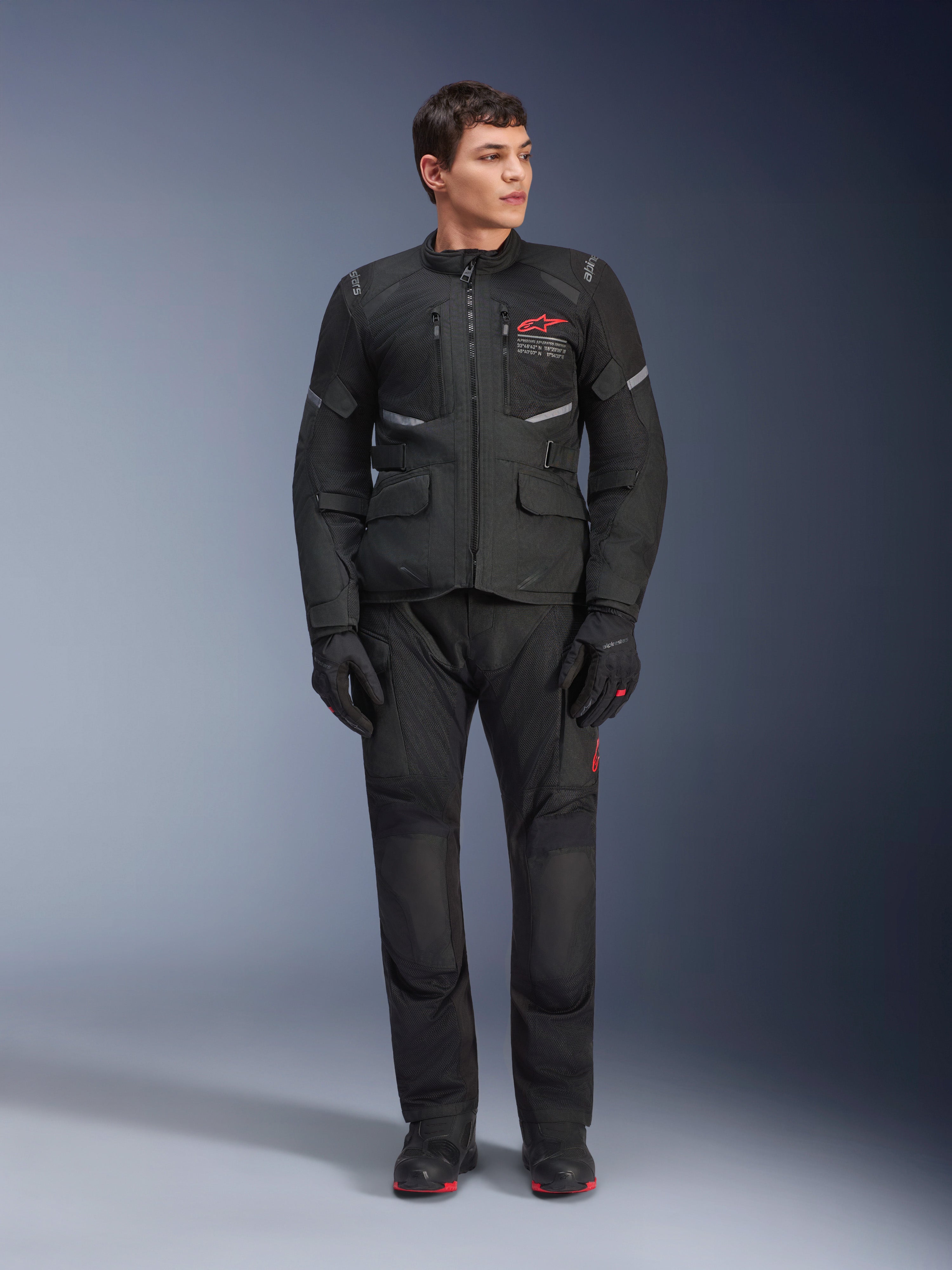 Alpinestars Andes Air Drystar® Hose, Motorrad-Tourenhose, Schwarz, mit Mesh-Belüftungseinsätzen und rotem Logo am Bein, getragen als Teil eines kompletten Motorrad-Outfits mit passender Jacke und Handschuhen, professionelle Adventure-Tourenausrüstung