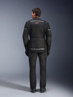Rückansicht eines Fahrers in der Alpinestars Andes Air Drystar® Jacke in Schwarz, mit großflächigen Mesh-Belüftungseinsätzen am Rücken, rotem Alpinestars-Logo und reflektierenden Akzenten, kombiniert mit passender Motorradhose und Handschuhen für Adventure-Touren.