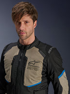 Alpinestars Andes Air Drystar® Jacke, Motorrad-Tourenjacke, Schwarz, Laurel Gray und Bright Blue, mit Mesh-Belüftungseinsätzen an der Brust, Alpinestars-Logo und funktionalen Reißverschlüssen, getragen von einem Mann in einem Studioporträt