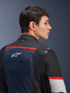 Alpinestars Andes Air Drystar® Jacke, Dunkelblau, Schwarz und Eisgrau, Nahaufnahme der Rückansicht an einem Model, mit atmungsaktivem Mesh-Einsatz, weißem Stern-Logo, roten Akzenten und Tech-Air®-Branding am Kragen, Motorrad-Tourenbekleidung für zwei Jahreszeiten