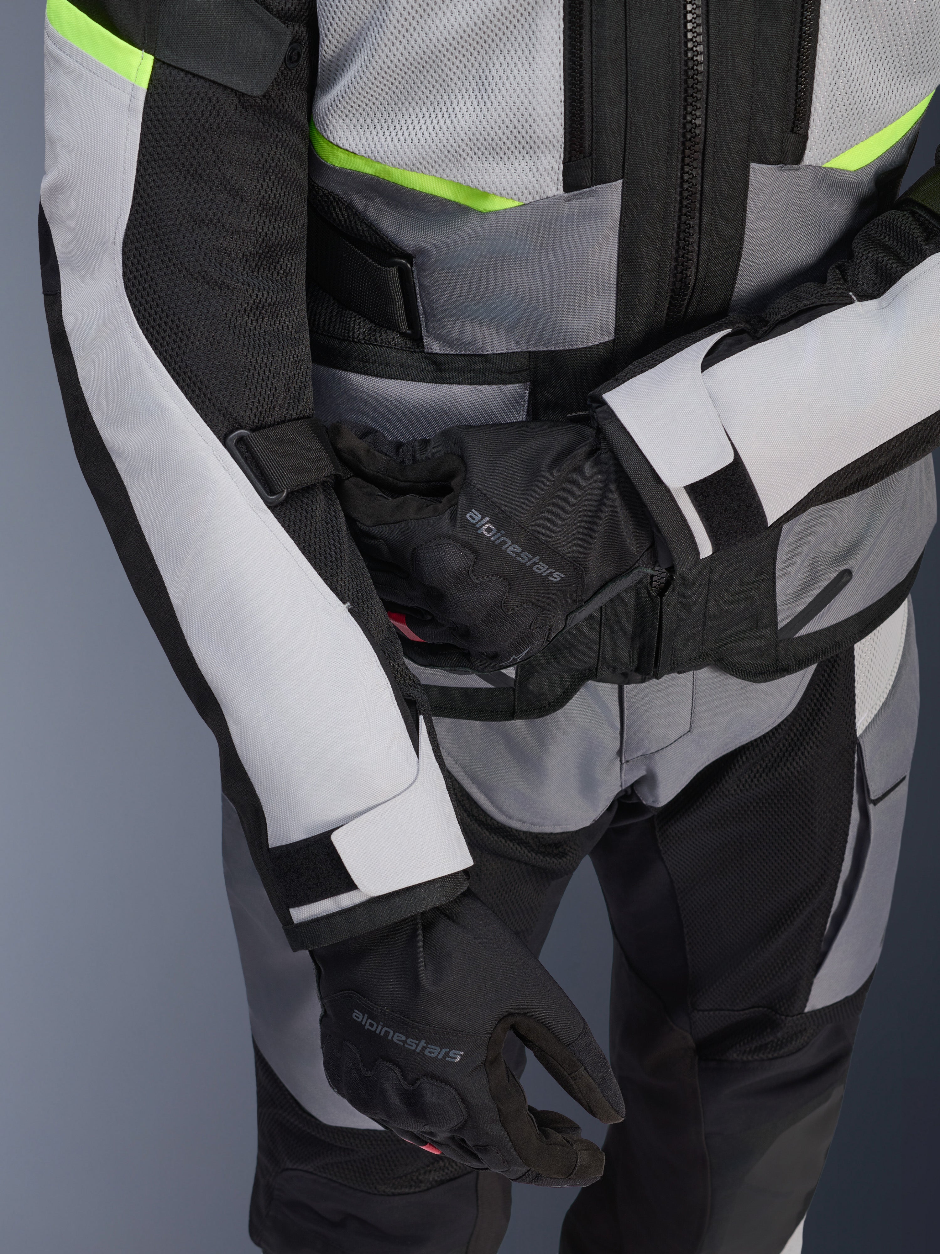 Alpinestars Andes Air Drystar® Jacket, Motorcycle Touring Jacket, Ice Gray and Dark Gray with Neon Yellow accents, close-up showing mesh panels and adjustment straps, worn with black Alpinestars gloves