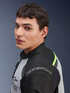 Close-up of a model wearing the Alpinestars Andes Air Drystar® Jacket in Ice Gray, Dark Gray, and Black, featuring neon yellow accents and mesh panels, with Alpinestars branding visible on the shoulder.
