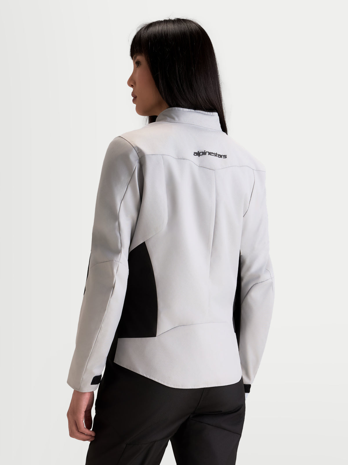 Alpinestars Stella C 1 Waterproof Jacke, urbane Damen-Motorradjacke in Eisgrau und Schwarz, Rückansicht an einem Model mit 3D-Rückenkonstruktion und Markenlogo im oberen Rückenbereich