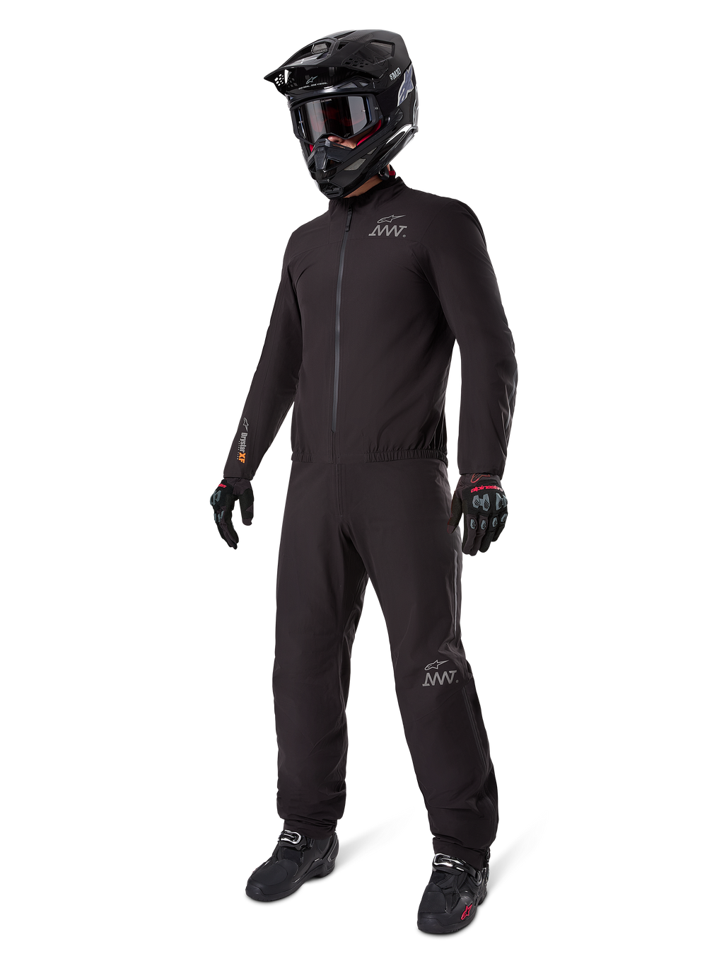 Alpinestars AMT-8 Stretch Drystar XF Liner, komplett schwarzer Adventure-Tourenanzug, wasser- und winddichte Jacke und Hose, kombiniert mit einem schwarzen Adventure-Helm, Brille, Handschuhen und Motorradstiefeln, mit AMT-Logos und Drystar XF-Branding an Ärmeln und Beinen.