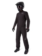 Alpinestars AMT-8 Stretch Drystar XF Liner, komplett schwarzer Adventure-Tourenanzug, wasser- und winddichte Jacke und Hose, kombiniert mit einem schwarzen Adventure-Helm, Brille, Handschuhen und Motorradstiefeln, mit AMT-Logos und Drystar XF-Branding an Ärmeln und Beinen.