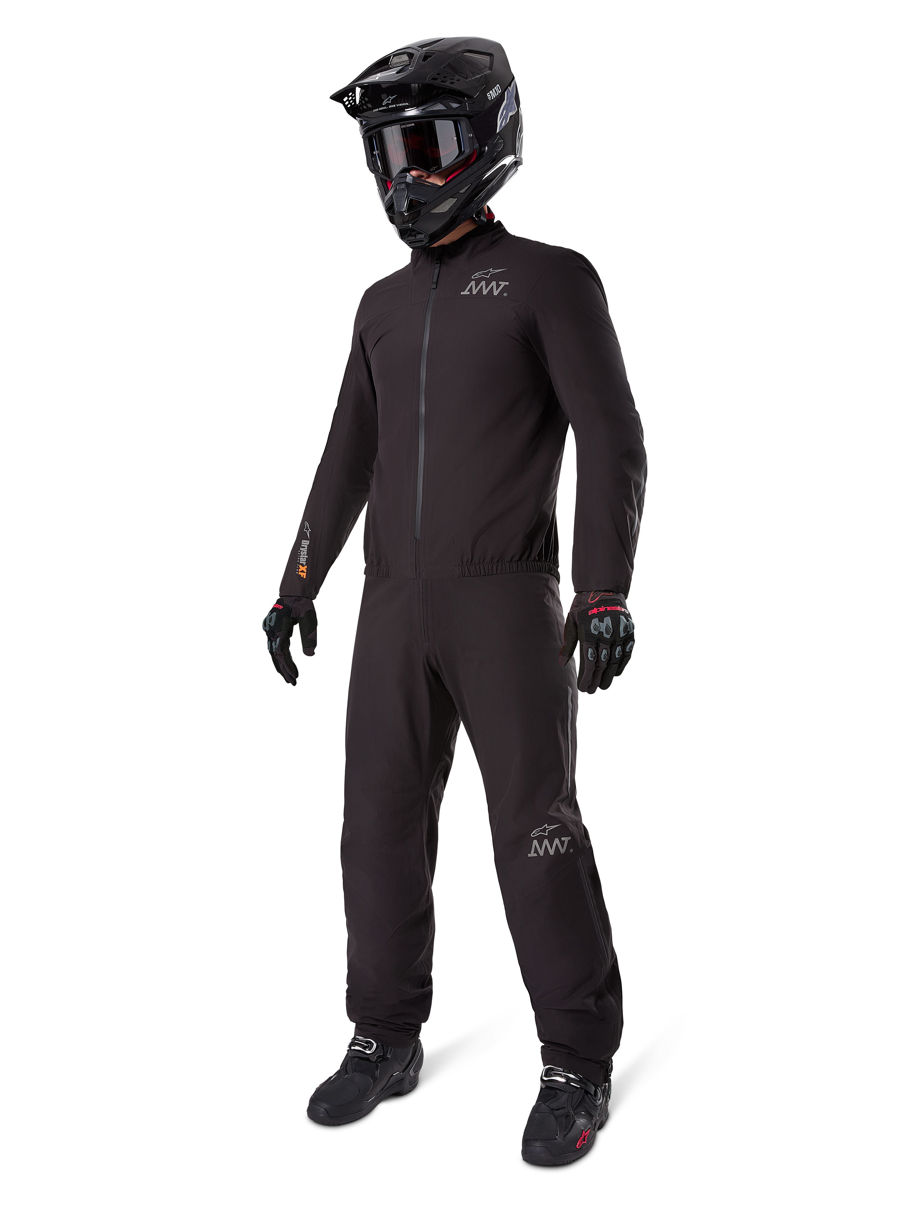 Alpinestars AMT-8 Stretch Drystar XF Liner, komplett schwarzer Adventure-Tourenanzug, wasser- und winddichte Jacke und Hose, kombiniert mit einem schwarzen Adventure-Helm, Brille, Handschuhen und Motorradstiefeln, mit AMT-Logos und Drystar XF-Branding an Ärmeln und Beinen.
