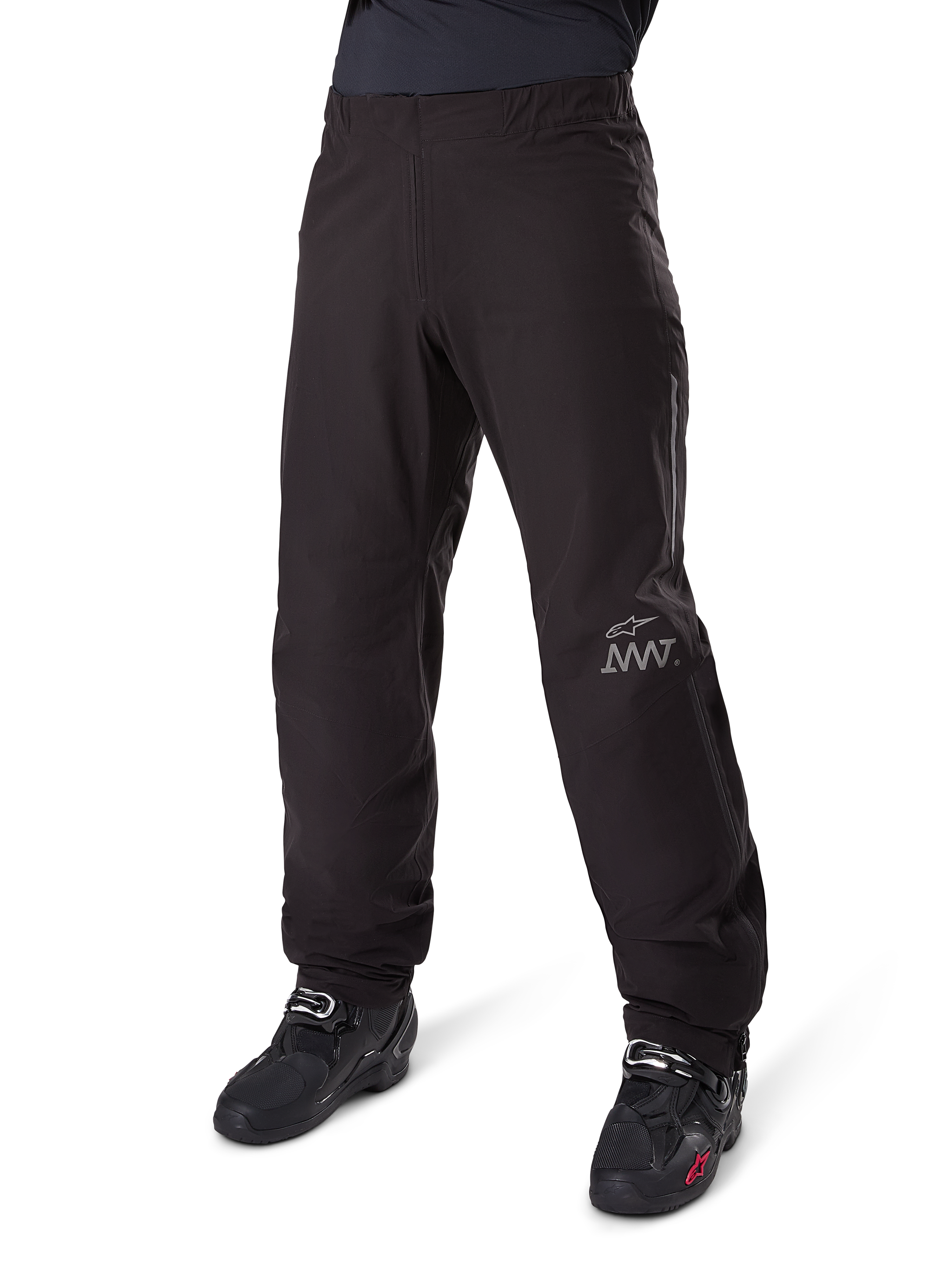 Alpinestars Amt 8 Stretch Drystar® XF Pant Liner, wasserdichte Motorradhose, Schwarz, mit grauem AMT-Logo am unteren linken Bein, getragen mit schwarzen Motorradstiefeln, funktionales Design für Allwetter-Adventure-Fahrten