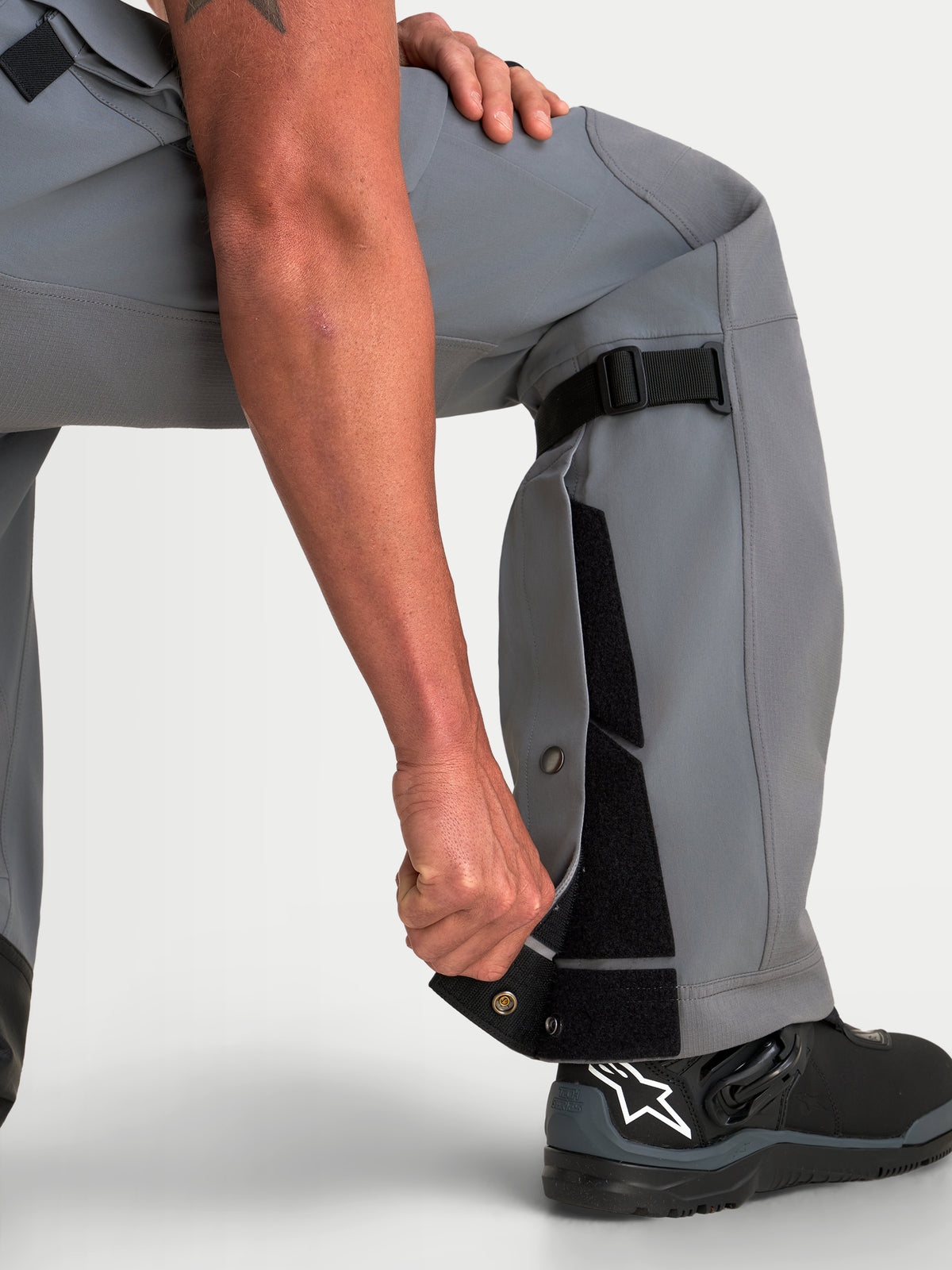 Alpinestars Maxdura Drystar XF Laminated Pants, Men's Adventure Motorcycle Pants in Dark Gray Black, featuring adjustable lower leg construction and over-the-boot fit with black riding boots