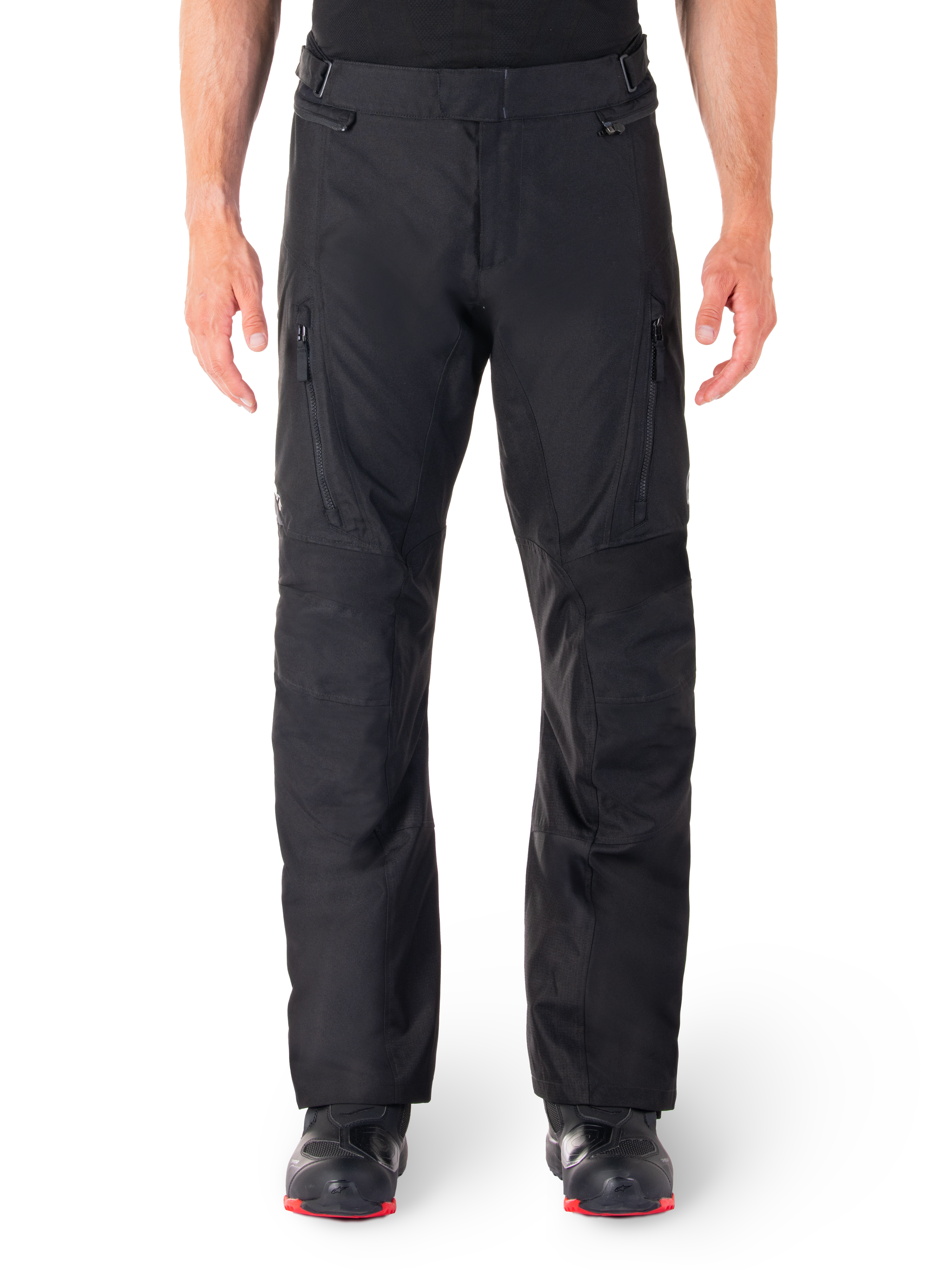 Alpinestars ST-1 Waterproof Pants, Black Motorcycle Touring Pants, front view featuring vertical zippered thigh pockets and adjustable waist tabs, worn with black red-soled boots, plain white background