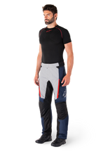 Alpinestars St-1 Waterproof Pants, Motorcycle Touring Pants, Dark Blue Black and Bright Red, worn by model with black base layer and black boots, features zippered pockets and Alpinestars logo on the leg