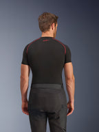 Alpinestars Cusco Drystar® Hose, schwarze Motorradhose, Rückansicht eines Fahrers in Adventure-Touring-Ausrüstung mit einem schwarzen kurzärmeligen Kompressionsoberteil mit roten Nähten, strapazierfähige Konstruktion aus Ripstop- und 600D-Gewebe.