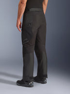 Alpinestars Cusco Drystar® Hose, Motorradhose, Schwarz, Dreiviertel-Rückansicht mit Reißverschlusstasche am Oberschenkel und vorgeformten Paneelen, getragen mit schwarzen Motorradstiefeln, strapazierfähiges Adventure-Touring-Design mit dezentem Branding