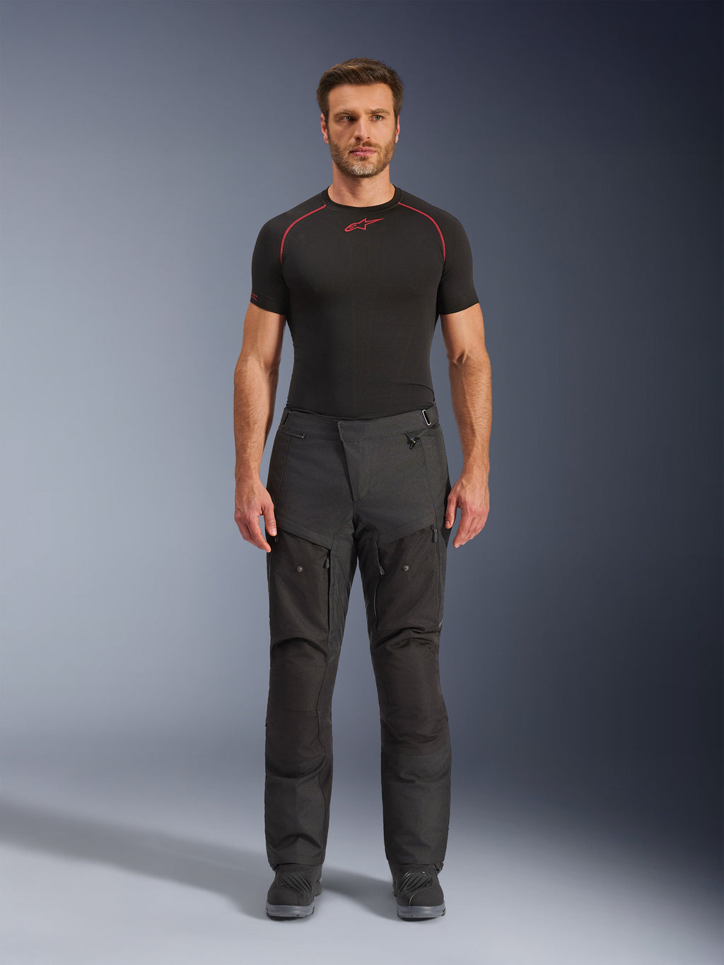 Alpinestars Cusco Drystar® Hose, Textil-Motorradhose, Schwarz, getragen von einem Modell mit schwarzem Baselayer und Stiefeln, Adventure-Touring-Design mit Belüftungspaneelen mit Reißverschluss an den Oberschenkeln und strapazierfähiger Multi-Panel-Konstruktion