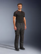 Alpinestars Cusco Drystar® Hose, schwarze Motorrad-Textilhose, getragen von einem Model mit schwarzem Base Layer und Stiefeln, Ripstop-Gewebe, große Cargotaschen mit „Terra“-Branding, ergonomisches Design für Adventure-Riding